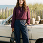 Winetasting Swiss Dot Peplum Blouse with Ruffle Neck - Woman Wearing Textured Blouse with Self-Tie - Suzy Shier