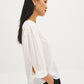 Button-front blouse in snow white with tie cuffs and pleated sleeves by Suzy Shier.