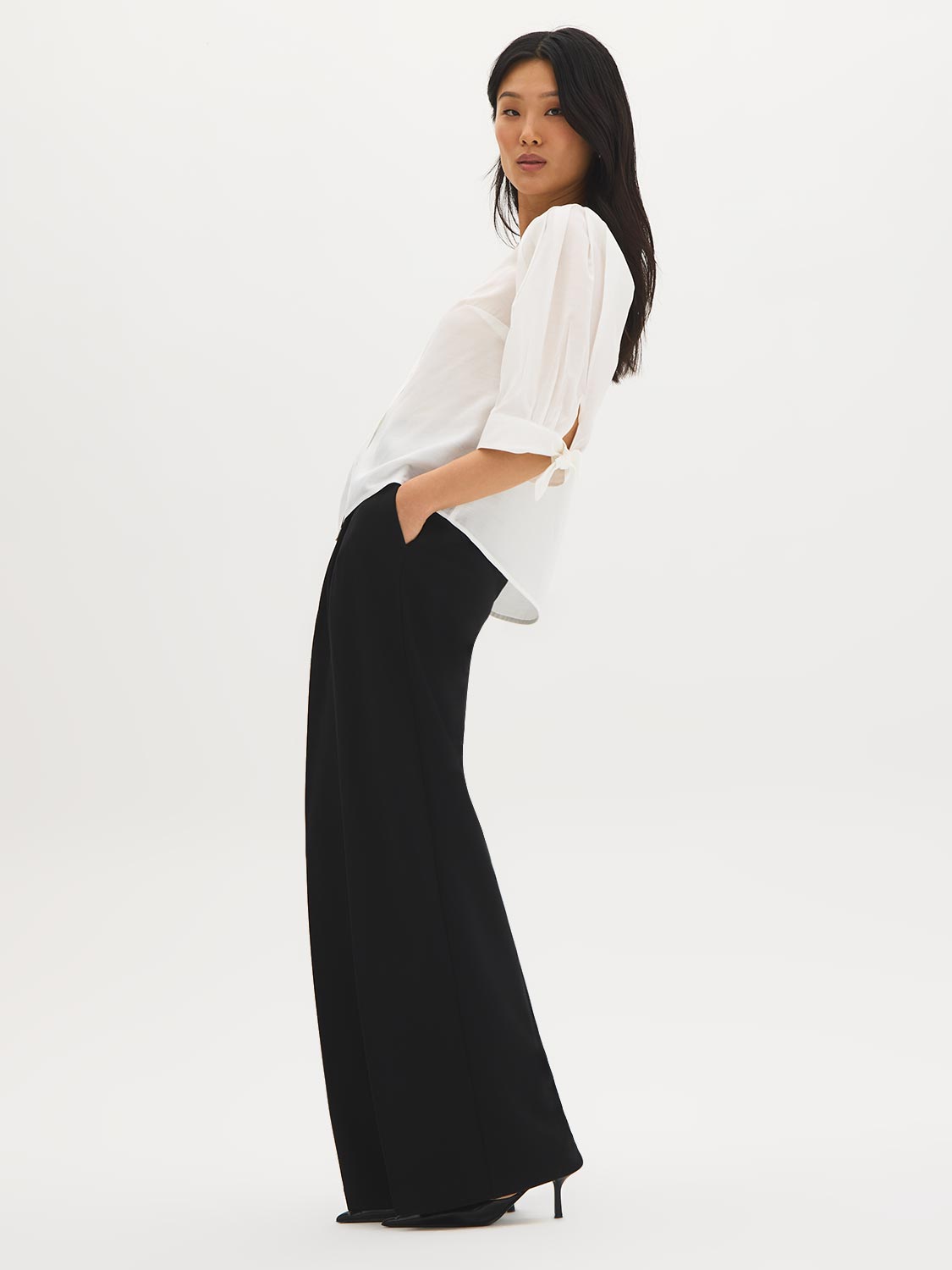 Button-front blouse in snow white with tie cuffs and pleated sleeves by Suzy Shier.