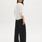 Button-front blouse in snow white with tie cuffs and pleated sleeves by Suzy Shier.