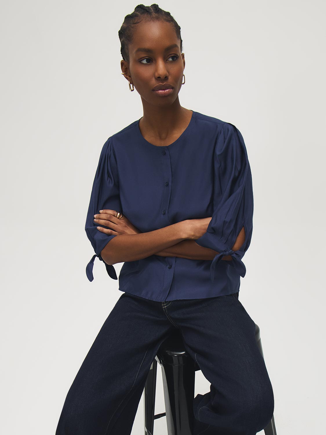 Button-front blouse in snow white with tie cuffs and pleated sleeves by Suzy Shier.