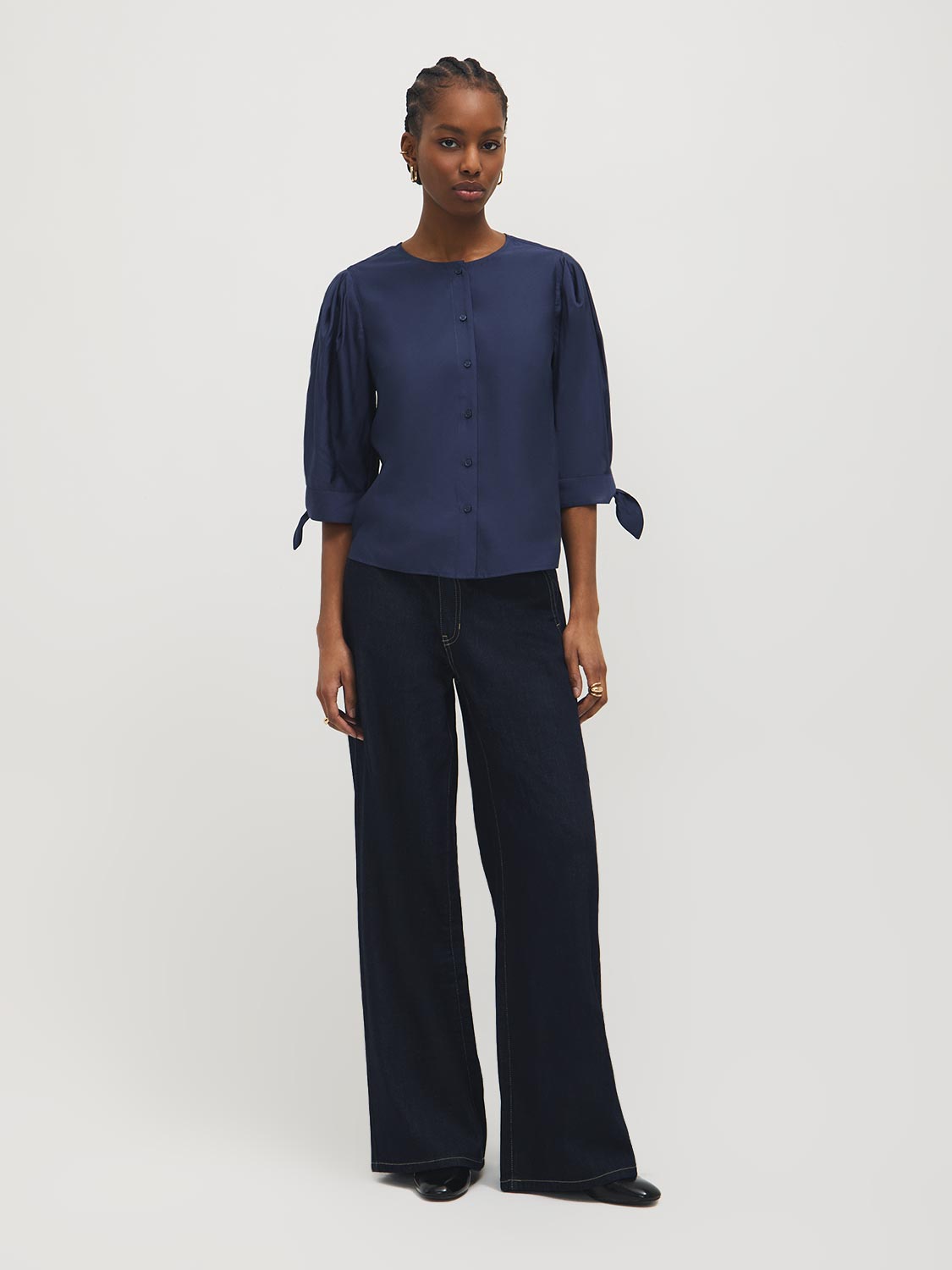 Button-front blouse in snow white with tie cuffs and pleated sleeves by Suzy Shier.