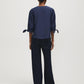 Button-front blouse in snow white with tie cuffs and pleated sleeves by Suzy Shier.
