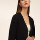 Knit crepe bolero with 3/4 sleeves and open-front design by Le Chateau.