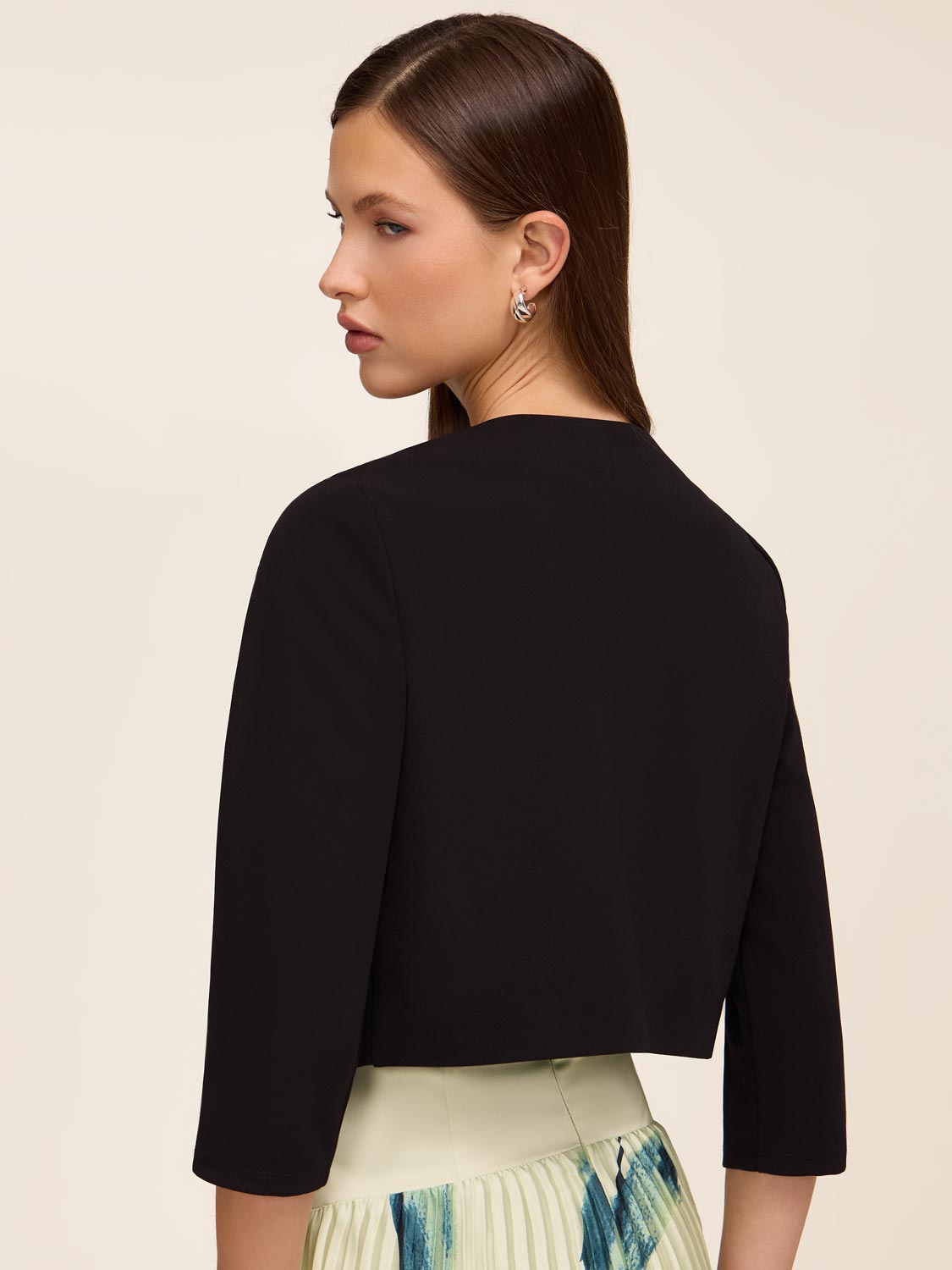 Knit crepe bolero with 3/4 sleeves and open-front design by Le Chateau.